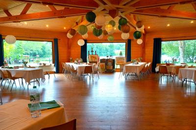 Tente tipi blanche installée sur une pelouse avec une table de pique-nique à proximité, entourée de verdure.