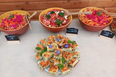 Tente tipi blanche installée sur une pelouse avec une table de pique-nique à proximité, entourée de verdure.