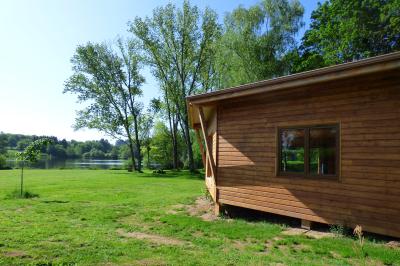 Tente tipi blanche installée sur une pelouse avec une table de pique-nique à proximité, entourée de verdure.