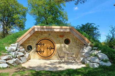 Tente tipi blanche installée sur une pelouse avec une table de pique-nique à proximité, entourée de verdure.