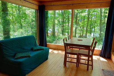 Tente tipi blanche installée sur une pelouse avec une table de pique-nique à proximité, entourée de verdure.