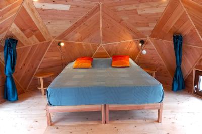 Tente tipi blanche installée sur une pelouse avec une table de pique-nique à proximité, entourée de verdure.