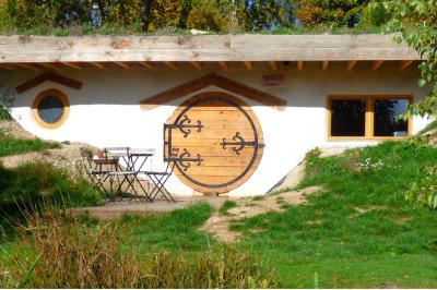 Tente tipi blanche installée sur une pelouse avec une table de pique-nique à proximité, entourée de verdure.
