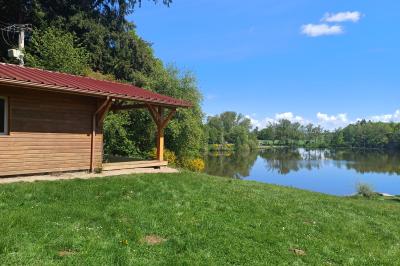 Tente tipi blanche installée sur une pelouse avec une table de pique-nique à proximité, entourée de verdure.