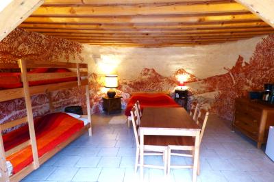 Tente tipi blanche installée sur une pelouse avec une table de pique-nique à proximité, entourée de verdure.