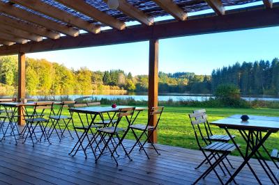 Tente tipi blanche installée sur une pelouse avec une table de pique-nique à proximité, entourée de verdure.