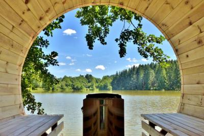 Cabane en bois avec toit en tuiles grises, grandes fenêtres et porte vitrée, située dans un espace arboré.