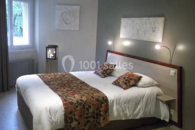 Salle de bain moderne avec douche arrondie, lavabo avec miroir éclairé et carrelage sombre.