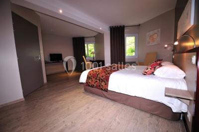 Salle de bain moderne avec douche arrondie, lavabo avec miroir éclairé et carrelage sombre.
