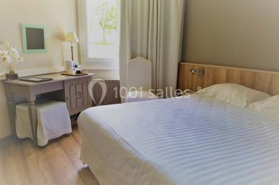 Salle de bain moderne avec douche arrondie, lavabo avec miroir éclairé et carrelage sombre.