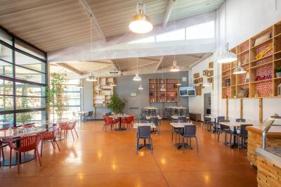 Façade d'un restaurant moderne avec terrasse, grandes baies vitrées et enseigne ’Restaurant Le Bon Plan’.