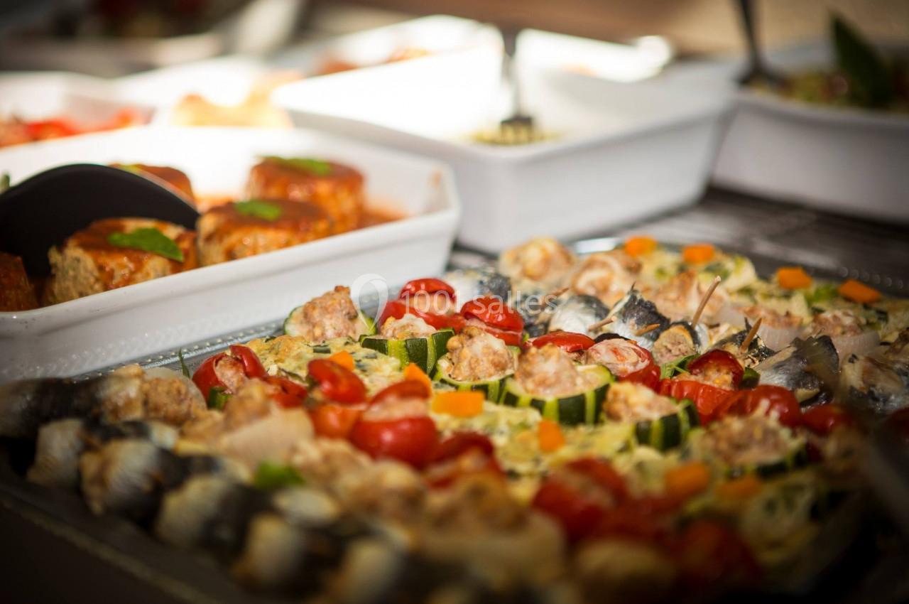 Plateau de plats variés comprenant des légumes grillés, des sardines et des préparations à base de viande.