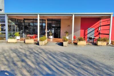 Façade d'un restaurant moderne avec terrasse, grandes baies vitrées et enseigne ’Restaurant Le Bon Plan’.