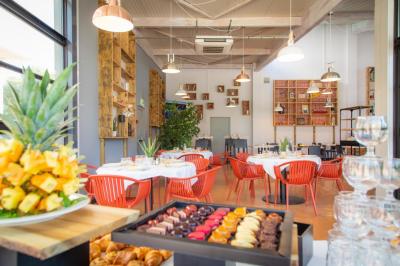 Façade d'un restaurant moderne avec terrasse, grandes baies vitrées et enseigne ’Restaurant Le Bon Plan’.