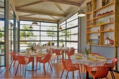 Façade d'un restaurant moderne avec terrasse, grandes baies vitrées et enseigne ’Restaurant Le Bon Plan’.