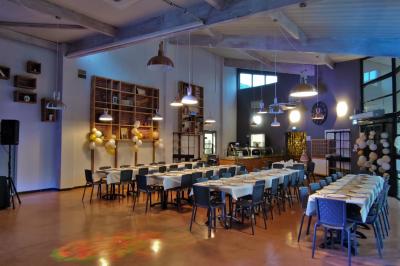 Façade d'un restaurant moderne avec terrasse, grandes baies vitrées et enseigne ’Restaurant Le Bon Plan’.