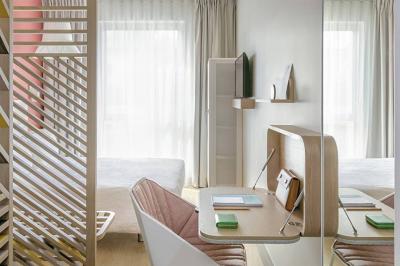 Salle lumineuse avec tables en marbre, chaises modernes, étagères décoratives et un bar en arrière-plan.