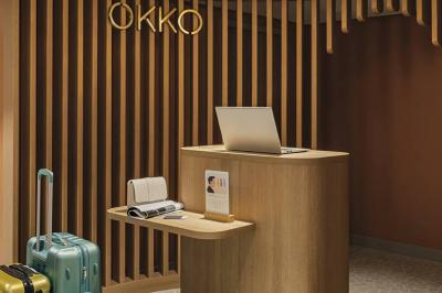 Salle lumineuse avec tables en marbre, chaises modernes, étagères décoratives et un bar en arrière-plan.