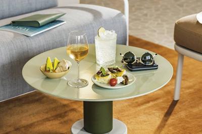 Salle lumineuse avec tables en marbre, chaises modernes, étagères décoratives et un bar en arrière-plan.