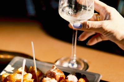 Trois bouteilles de vin aux étiquettes colorées posées sur un sol fleuri de marguerites.