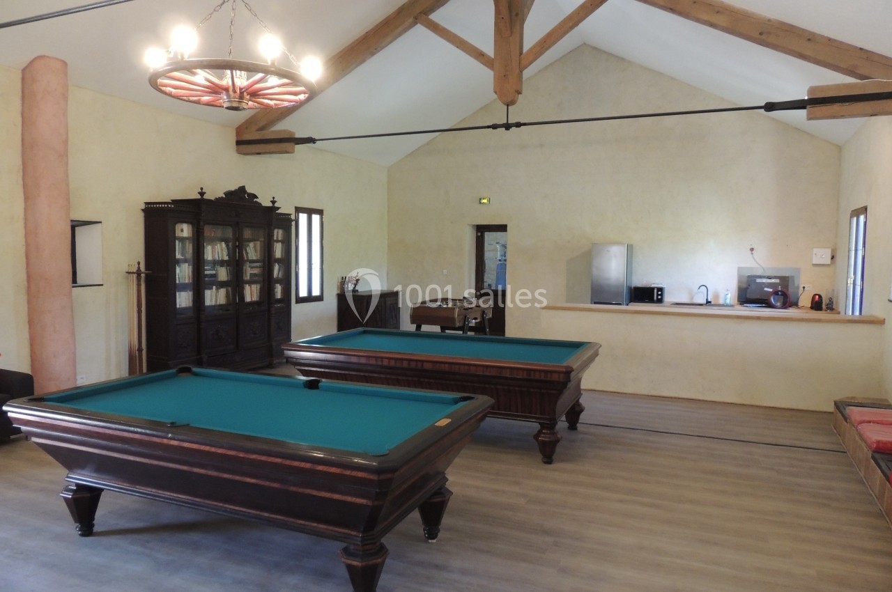 Salle de loisirs avec deux tables de billard, un baby-foot, une bibliothèque et un coin kitchenette.