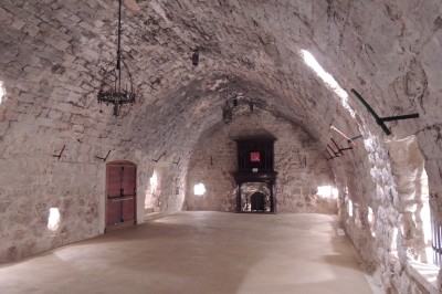 Trois bouteilles de vin aux étiquettes colorées posées sur un sol fleuri de marguerites.