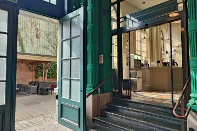 Un coussin jaune sur un lit blanc avec une pancarte suspendue indiquant un message écologique.