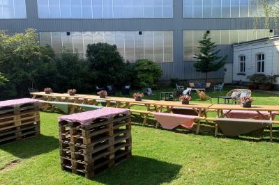 Un coussin jaune sur un lit blanc avec une pancarte suspendue indiquant un message écologique.