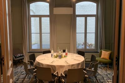 Un coussin jaune sur un lit blanc avec une pancarte suspendue indiquant un message écologique.