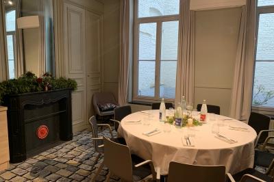 Un coussin jaune sur un lit blanc avec une pancarte suspendue indiquant un message écologique.