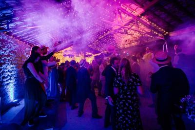 Salle de bain lumineuse avec baignoire moderne, échelle en bois, miroir incliné et double vasque sur meuble blanc.