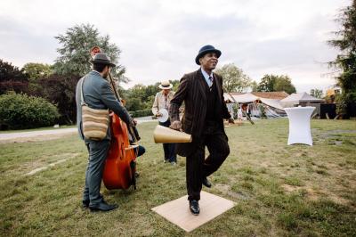 Salle de bain lumineuse avec baignoire moderne, échelle en bois, miroir incliné et double vasque sur meuble blanc.