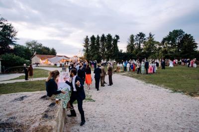 Salle de bain lumineuse avec baignoire moderne, échelle en bois, miroir incliné et double vasque sur meuble blanc.