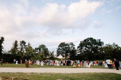 Salle de bain lumineuse avec baignoire moderne, échelle en bois, miroir incliné et double vasque sur meuble blanc.