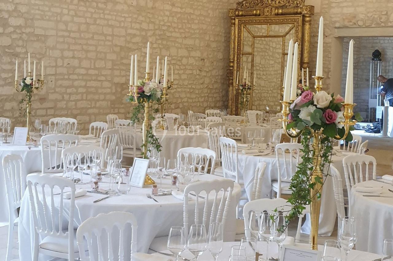 Location salle Assay (Indre-et-Loire) - Chateau de Basché #4 Salle de réception décorée avec des tables rondes, nappes blanches, chandeliers dorés et compositions florales.