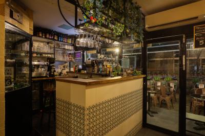 Verres de cocktails variés, dont des shots avec citrons verts et des spritz orange, posés sur des tables en bois.