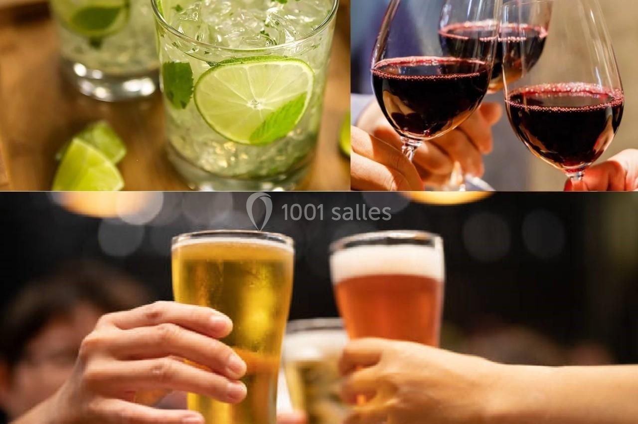 Verres de cocktails, de vin rouge et de bière levés dans un contexte festif.