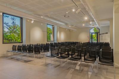 Vue nocturne d'un événement en plein air avec des stands sous une tente éclairée et des participants rassemblés.