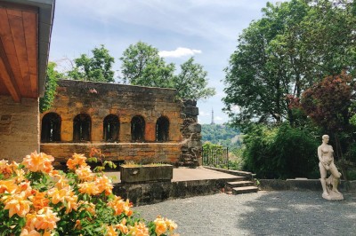 Tables rondes dressées avec nappes noires, serviettes pliées et verres dans une salle lumineuse avec grandes fenêtres.
