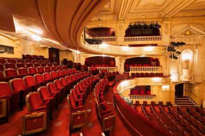 Escalier et couloir décoré de rouge avec fresque murale sculptée, éclairage chaleureux et moquette au sol.