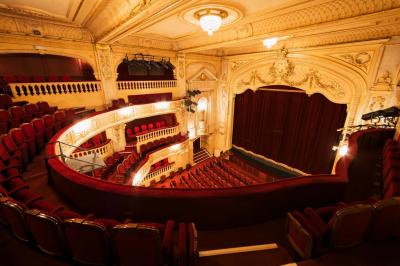 Escalier et couloir décoré de rouge avec fresque murale sculptée, éclairage chaleureux et moquette au sol.
