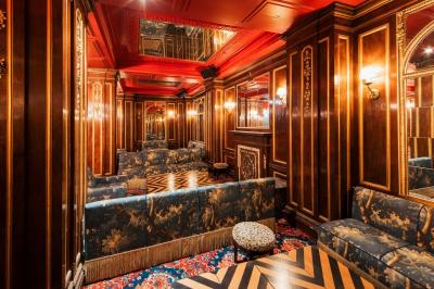 Escalier et couloir décoré de rouge avec fresque murale sculptée, éclairage chaleureux et moquette au sol.