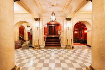 Escalier et couloir décoré de rouge avec fresque murale sculptée, éclairage chaleureux et moquette au sol.