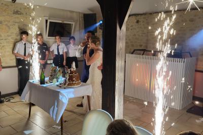 Homme souriant portant un casque audio et un costume sombre, éclairé par une lumière douce sur fond noir.