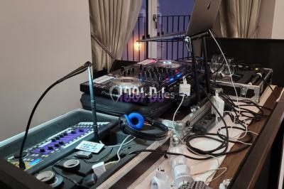 Salle de réception avec piste de danse, éclairage violet, équipement audio et décoration florale.