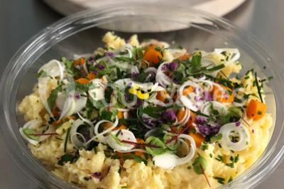 Atelier culinaire avec préparation de sushis et makis, ingrédients frais et ustensiles disposés sur une table.