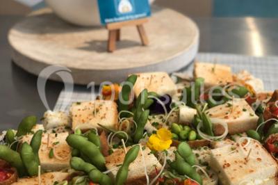 Atelier culinaire avec préparation de sushis et makis, ingrédients frais et ustensiles disposés sur une table.