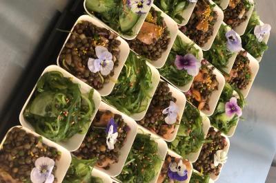 Atelier culinaire avec préparation de sushis et makis, ingrédients frais et ustensiles disposés sur une table.