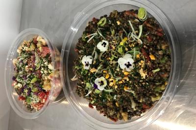 Atelier culinaire avec préparation de sushis et makis, ingrédients frais et ustensiles disposés sur une table.