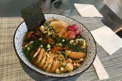 Atelier culinaire avec préparation de sushis et makis, ingrédients frais et ustensiles disposés sur une table.